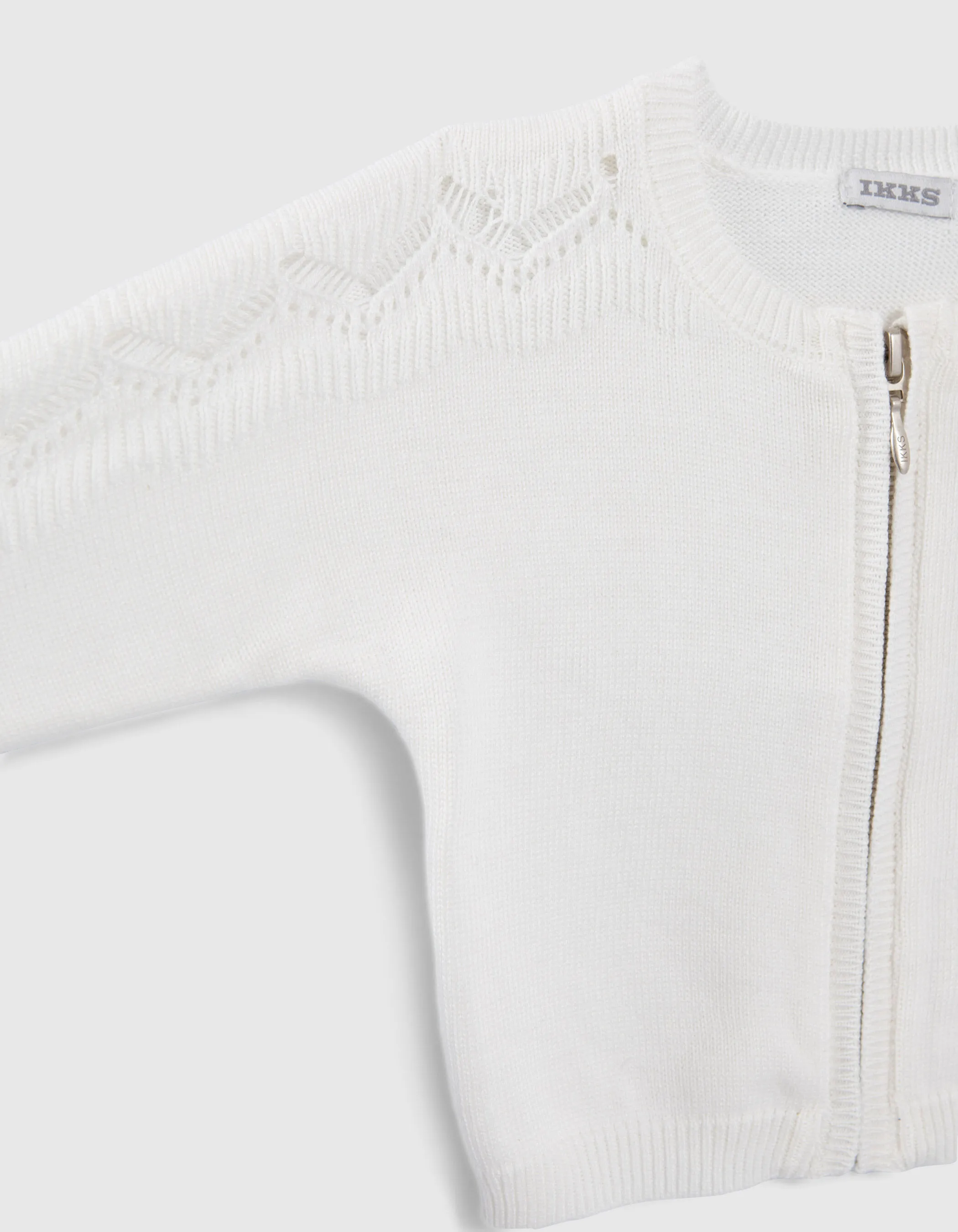 Baby girl's ivory knit cardigan with openwork sleeves.